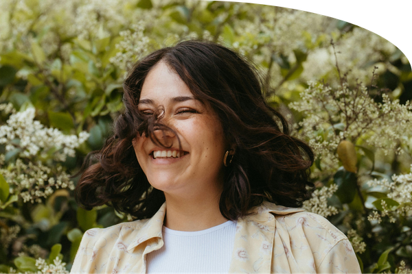 Fit Mind Wellness clinician smiling among white flowers